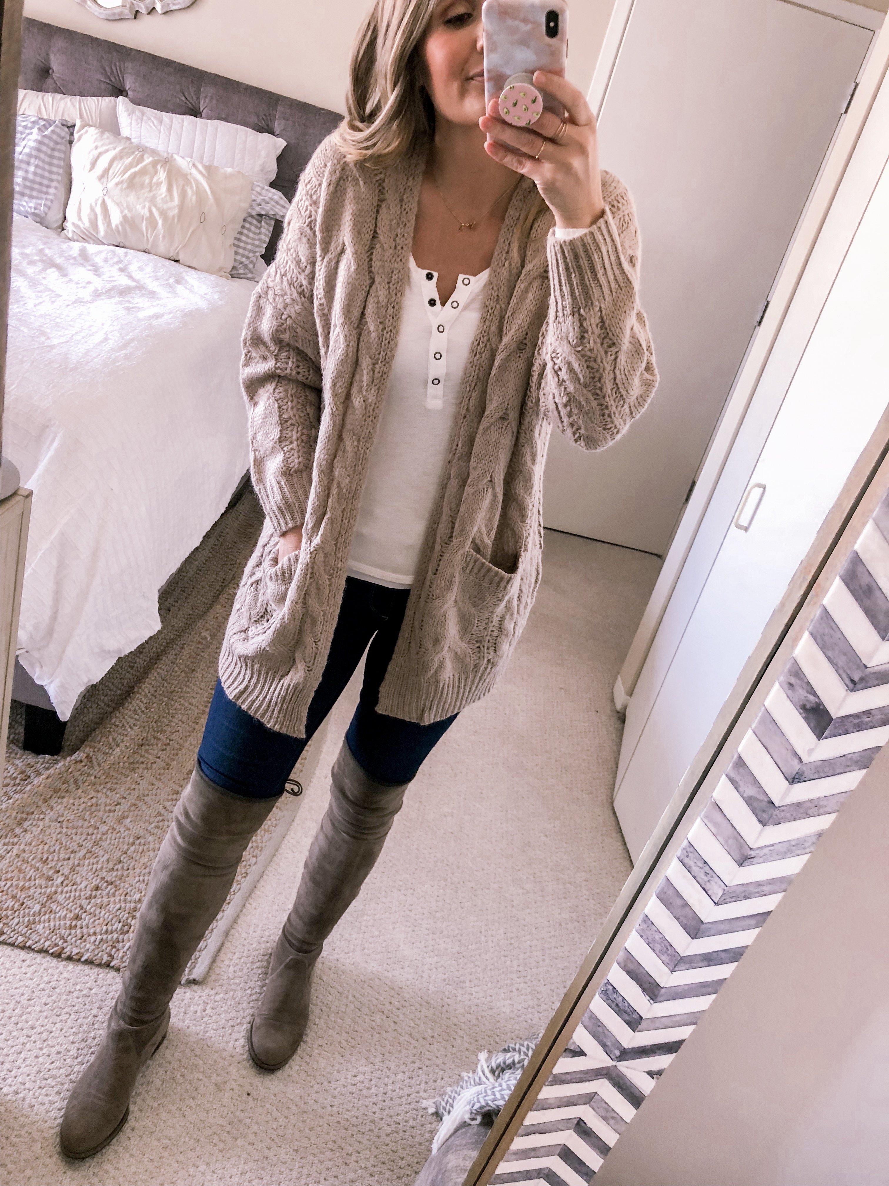 Popular Chicago fashion blogger Visiosn of Vogue styles a beige cardigan with a white henley and suede over the knee boots for an office outfit idea.