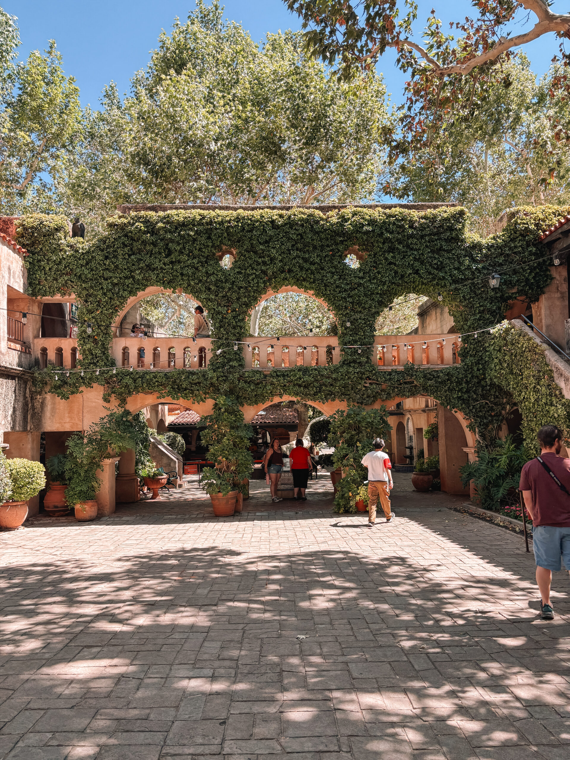 Colorful storefronts and artisan galleries at Tlaquepaque Arts & Crafts Village in Sedona, Arizona, featuring cobblestone walkways and decorative arches