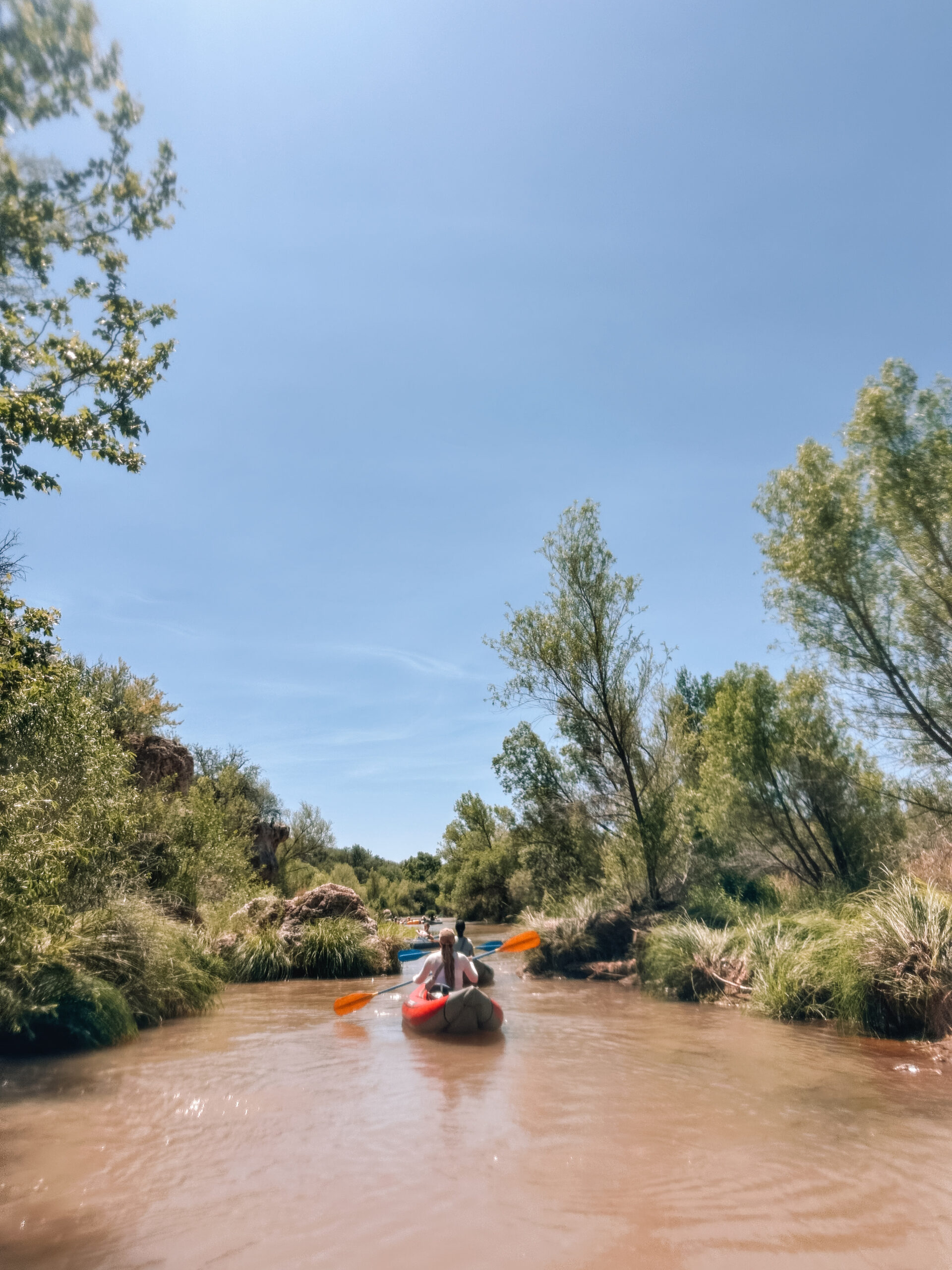 Kayakers paddling down the Verde River near Sedona, Arizona during the Water to Wine Tour with scenic desert views and vineyards in the background